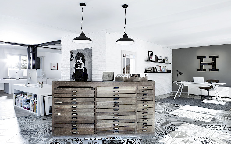Offenes Buero der Heller Druck AG mit historischem Planschrank, weisser Backsteinwand und gemustertem Zementfliesenboden